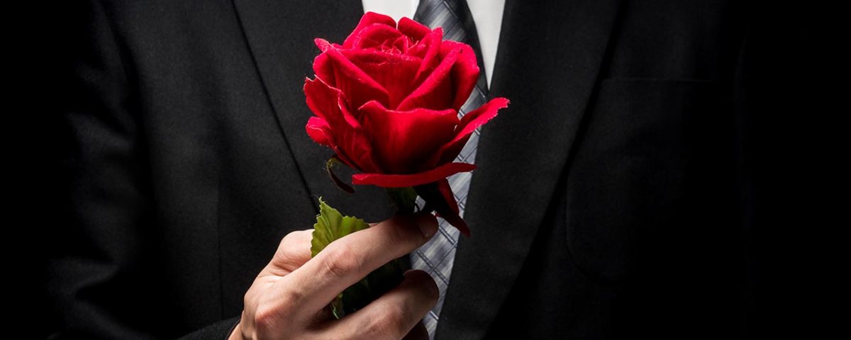 man in tux holding rose