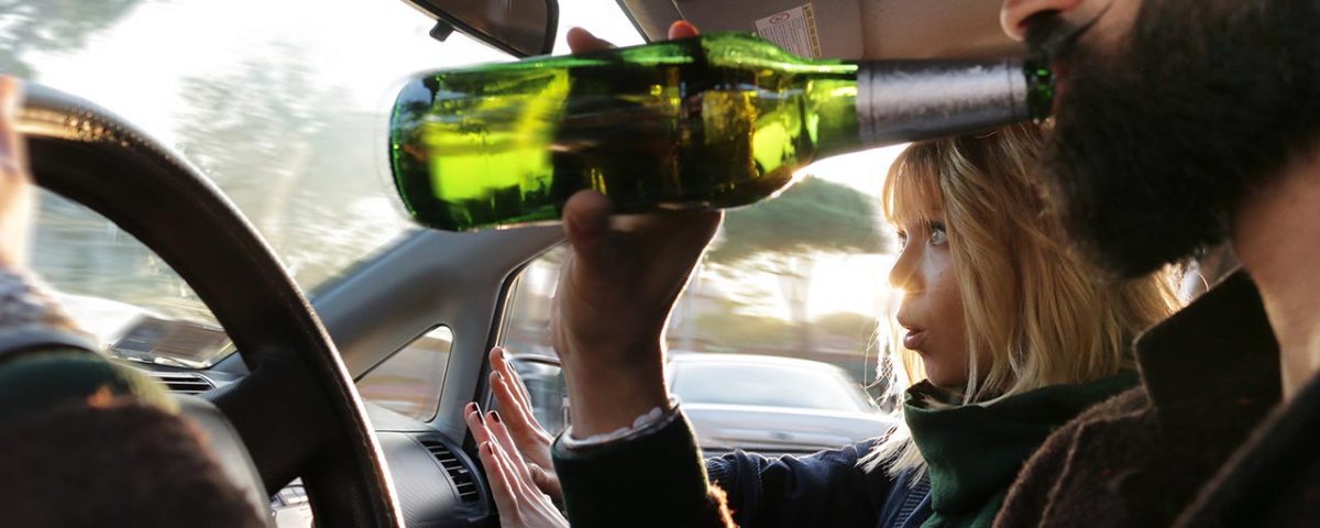 man drinking at wheel