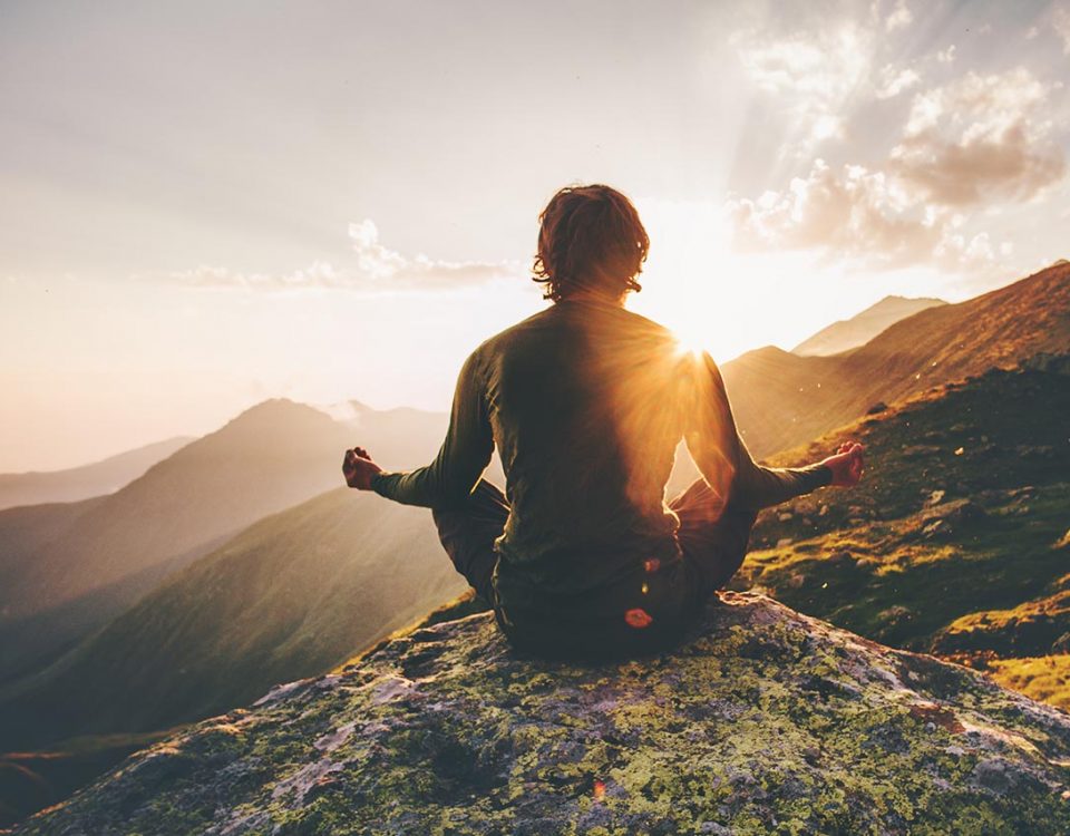 man meditating on mountain